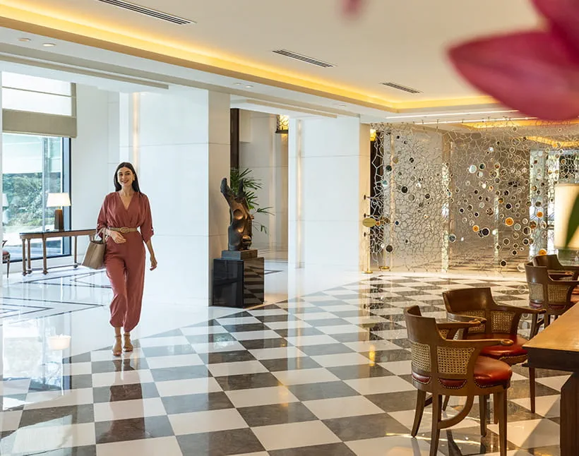Woman walking through lobby of The Oberoi, New Delhi.